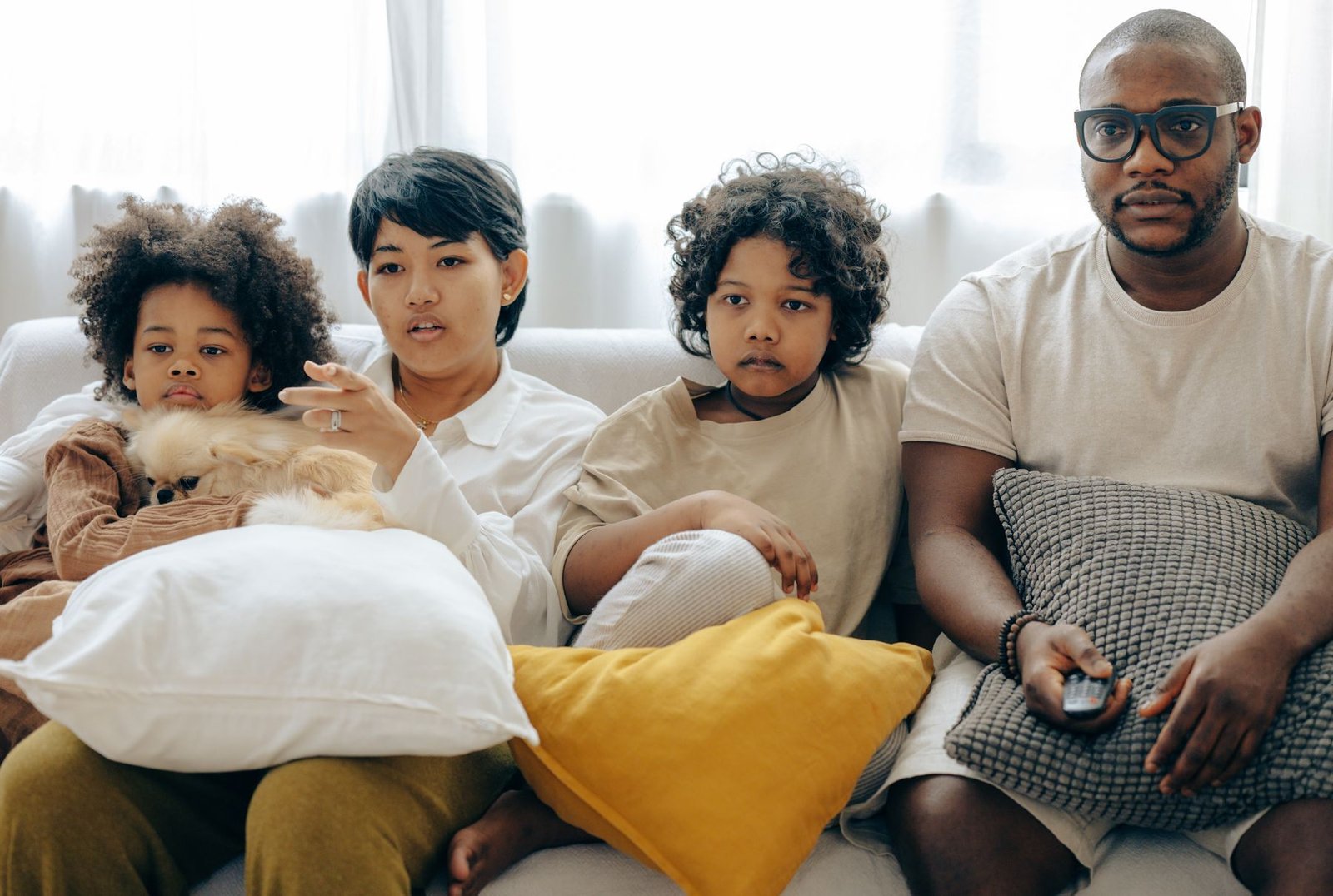 Family sitting together on a sofa watching television