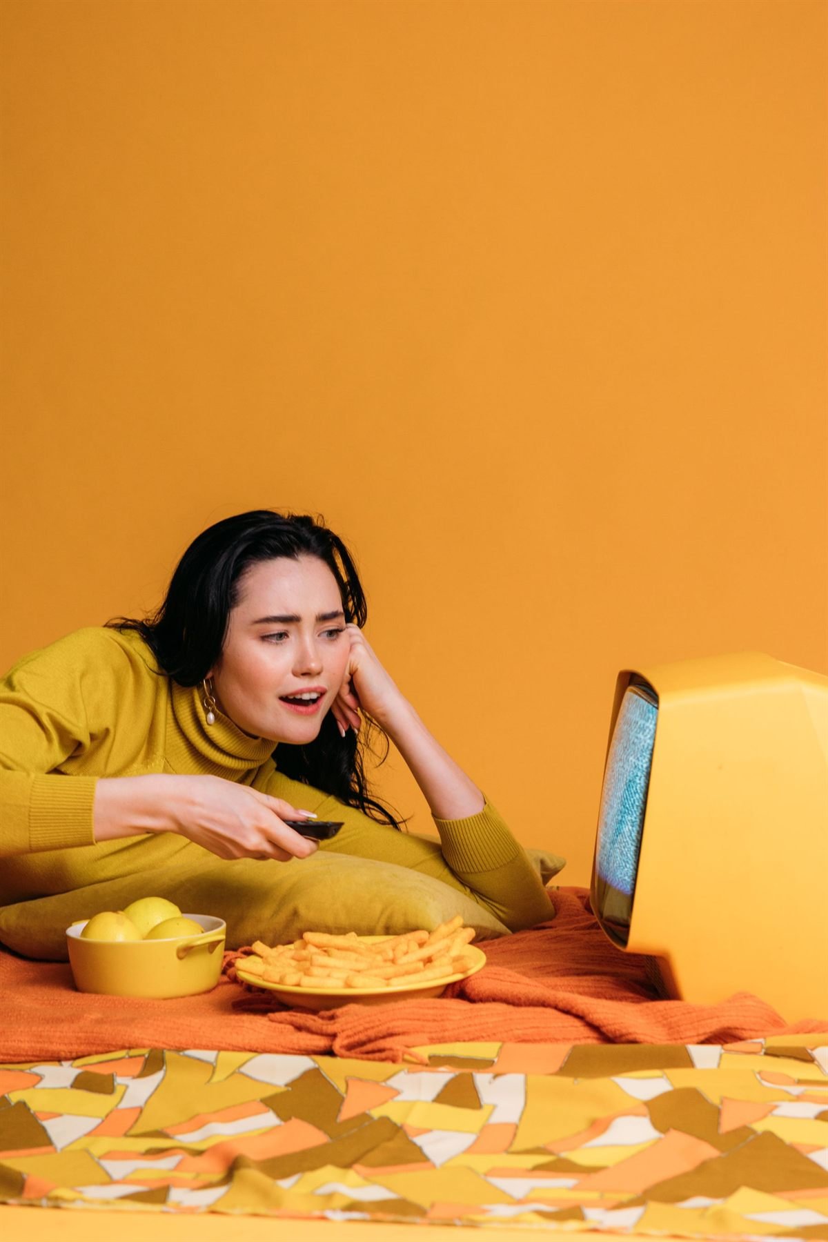 Woman holding a remote in front of a television that has lost its signal